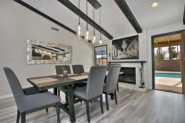 a view of a dining room with furniture a fireplace and wooden floor