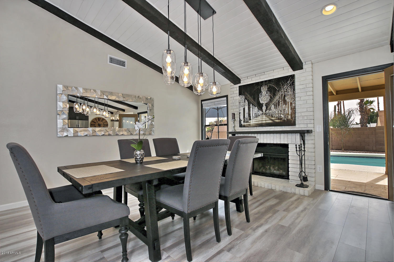 6521 East Grandview Drive Scottsdale, AZ 85254 - Photo 11 of 27 a view of a dining room with furniture a fireplace and wooden floor