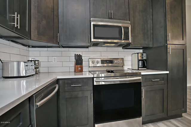 a kitchen with stainless steel appliances granite countertop a sink stove and microwave