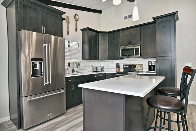 a kitchen with stainless steel appliances a refrigerator sink and microwave