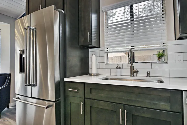 a kitchen with stainless steel appliances a sink and a refrigerator