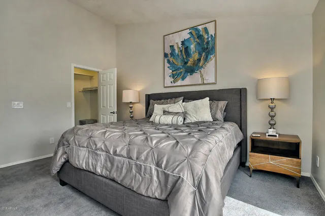 a bedroom with a bed a painting on the wall and a painting on the wall