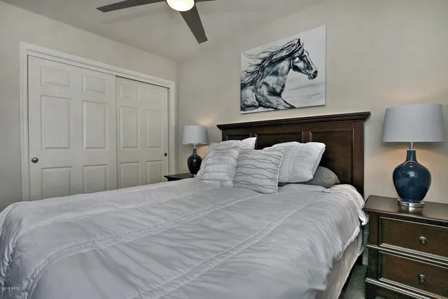 a bedroom with a bed and lamp on dresser