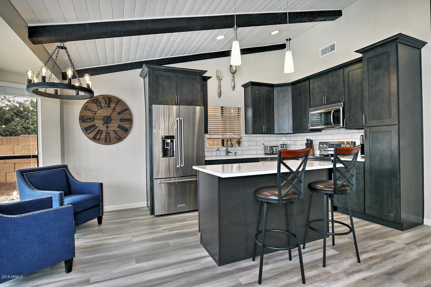 6521 East Grandview Drive Scottsdale, AZ 85254 - Photo 9 of 27 a kitchen with stainless steel appliances granite countertop a refrigerator a sink dishwasher a dining table and chairs with wooden floor