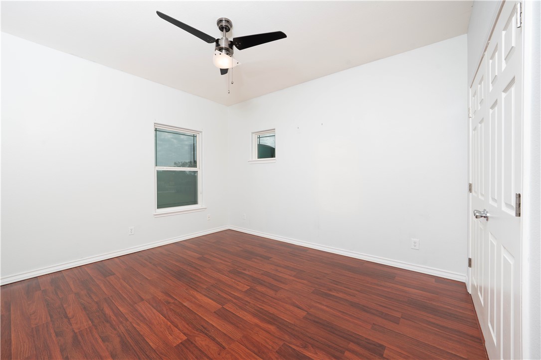 1034 Graham Road Corpus Christi, TX 78418 - Photo 30 of 40 an empty room with wooden floor fan and windows
