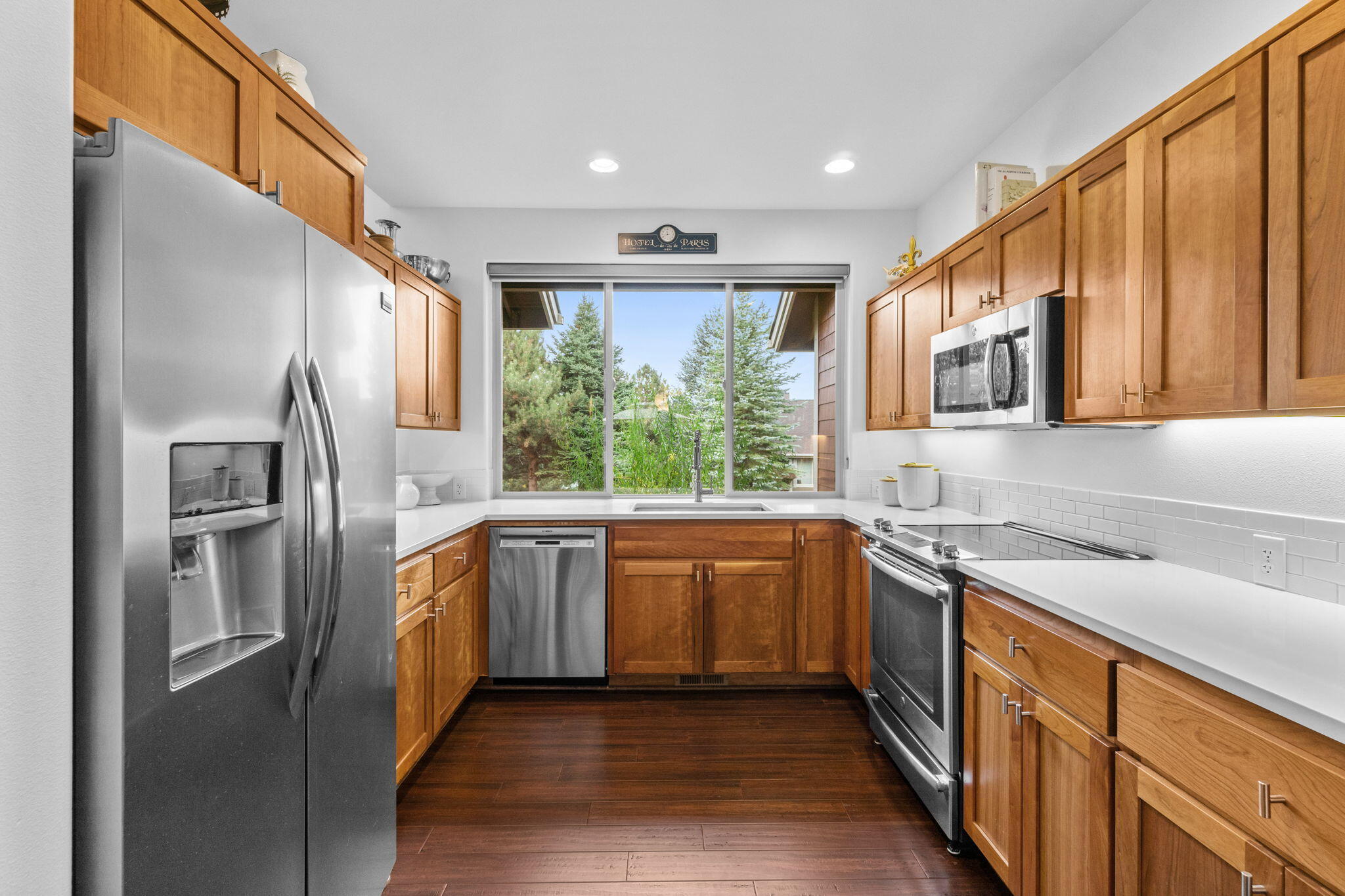 10942 Village Loop Redmond, OR 97756 - Photo 7 of 45 a kitchen with stainless steel appliances granite countertop a refrigerator a sink dishwasher a stove with wooden cabinets and floors