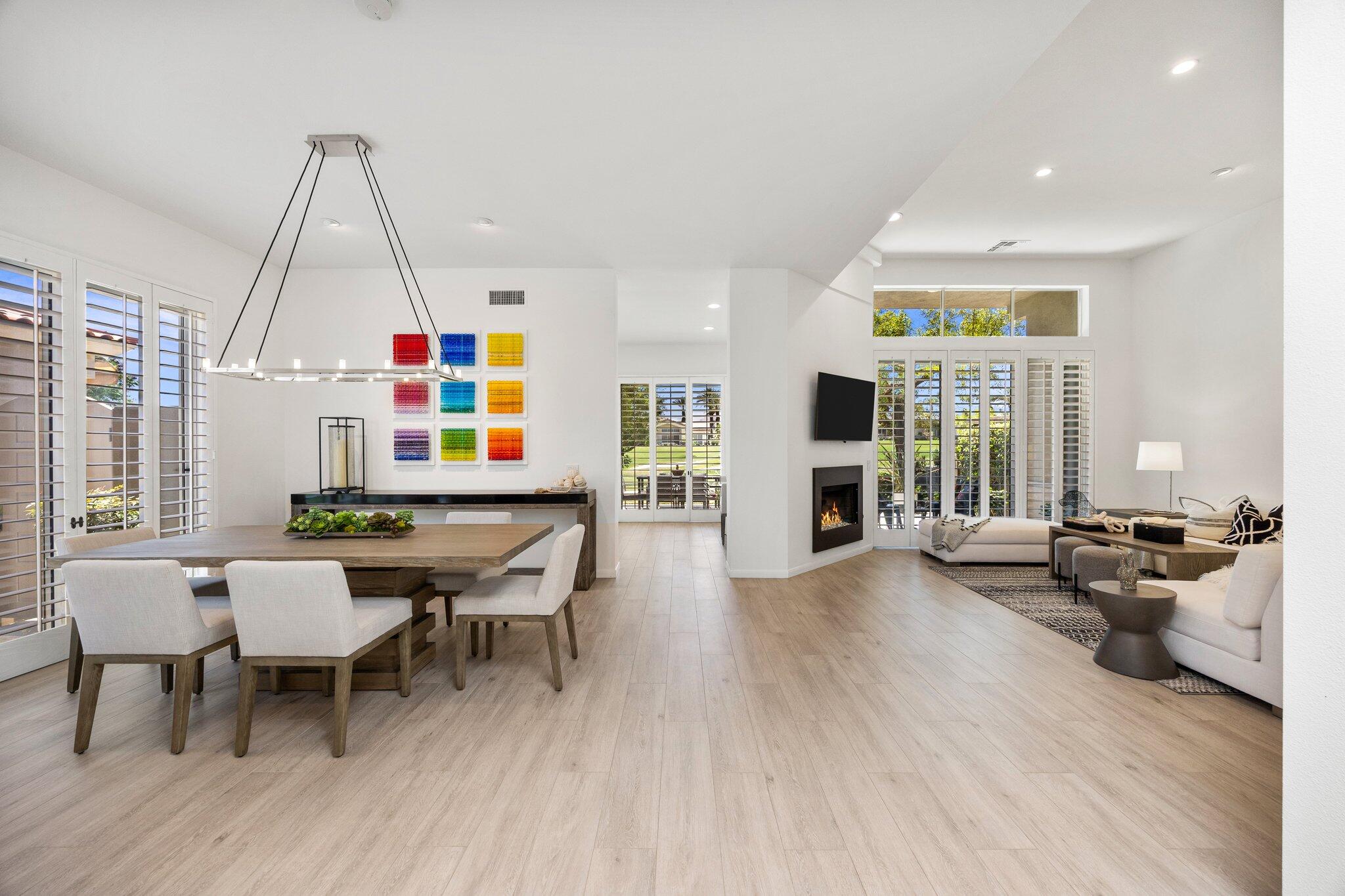 a dining room with wooden floor and large window