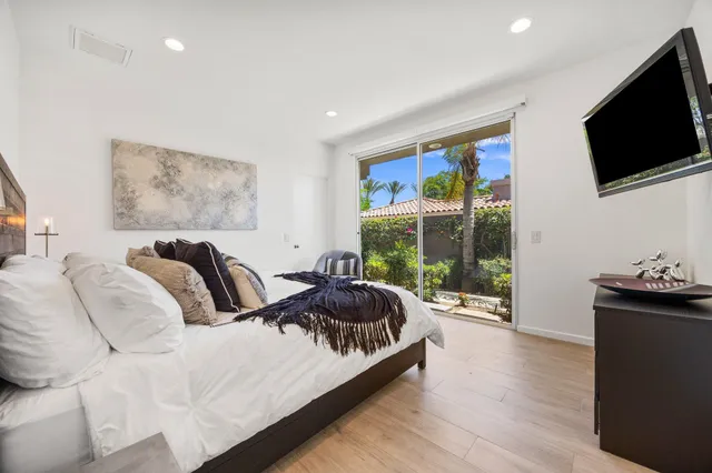 a spacious bedroom with a bed and a flat screen tv