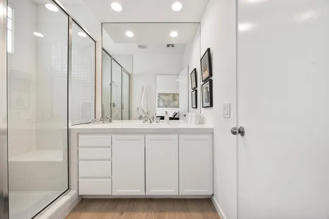 a bathroom with a double vanity sink a mirror and a shower