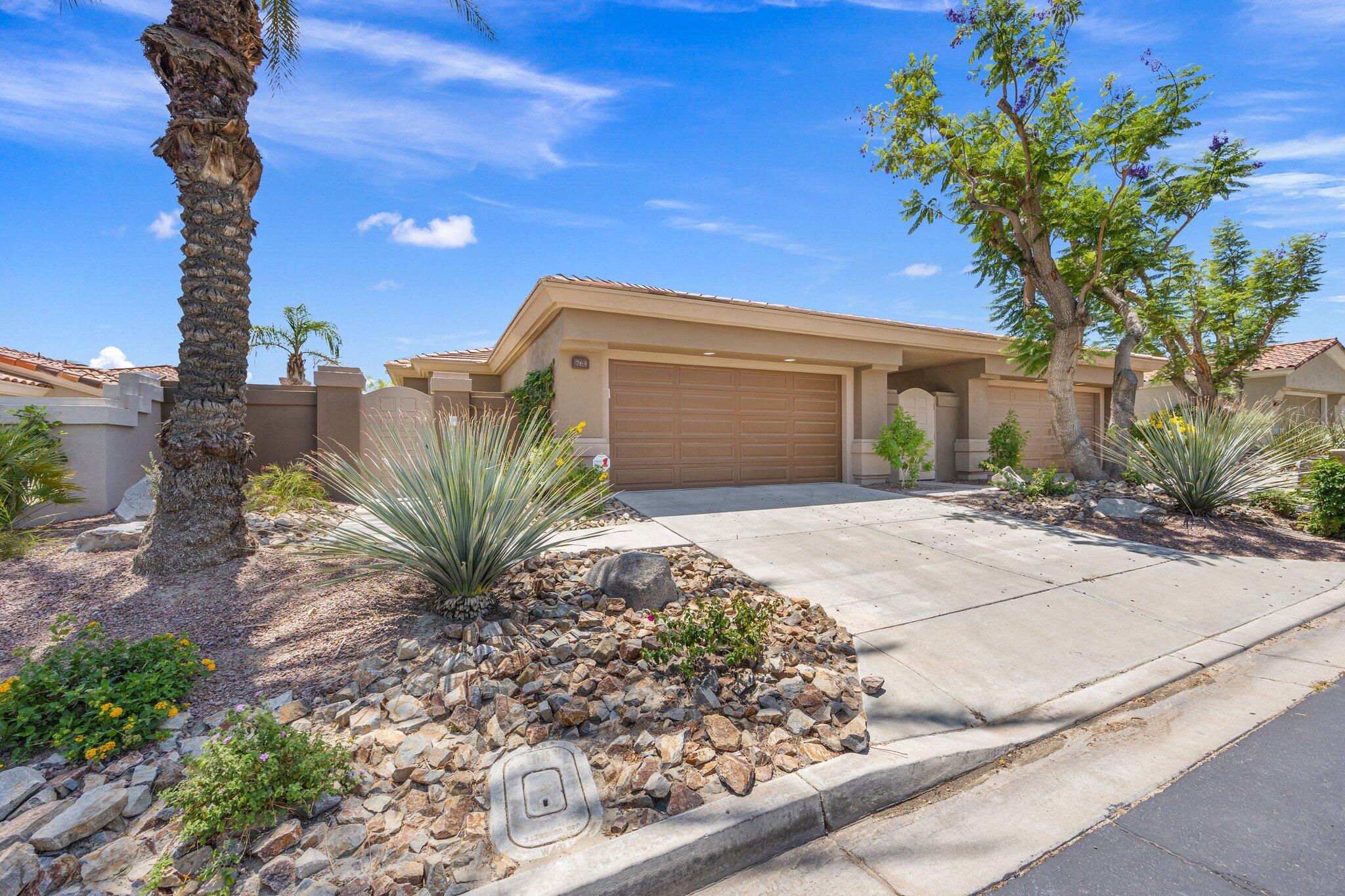 763 Box Canyon Trail Palm Desert, CA 92211 - Photo 31 of 48 a front view of a house with a yard and potted plants