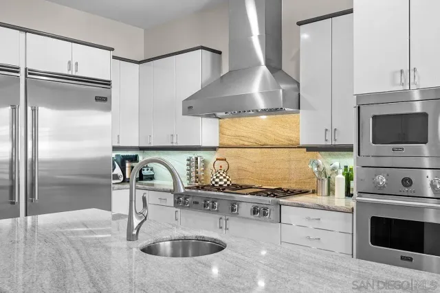 a kitchen with granite countertop a sink stainless steel appliances and cabinets