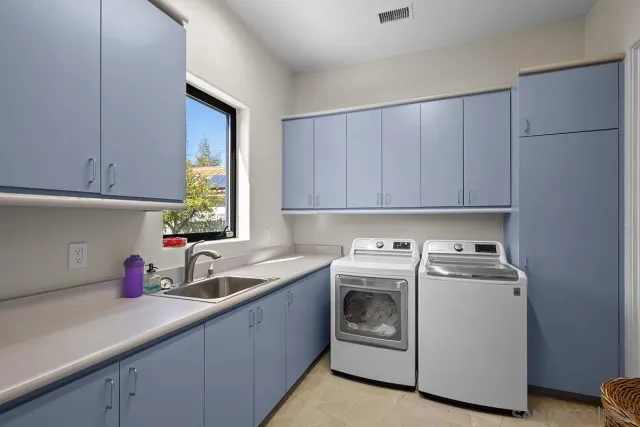 a kitchen with a sink white cabinets and white appliances