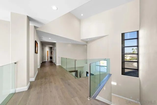 a view of a hallway with wooden floor and entryway
