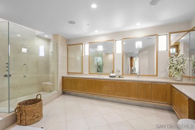 a bathroom with a tub a sink and a glass door shower