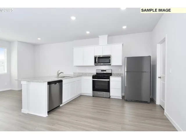 a kitchen with a refrigerator a stove top oven and white kitchen
