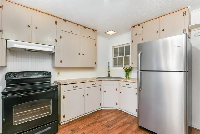 a kitchen with a refrigerator and a stove top oven