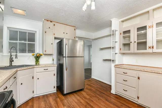 a kitchen with cabinets stainless steel appliances a sink and a window