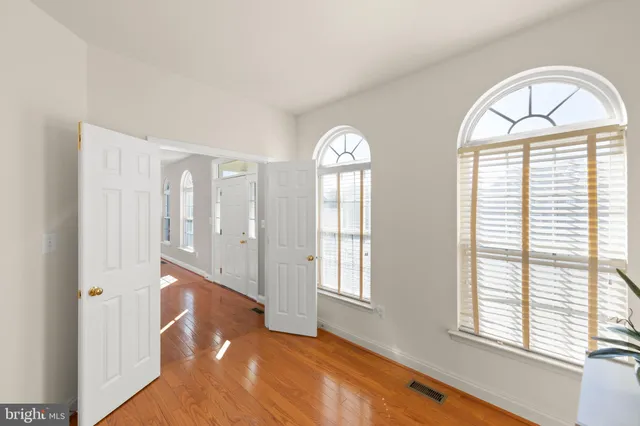 a spacious bedroom with a bed and wooden floor