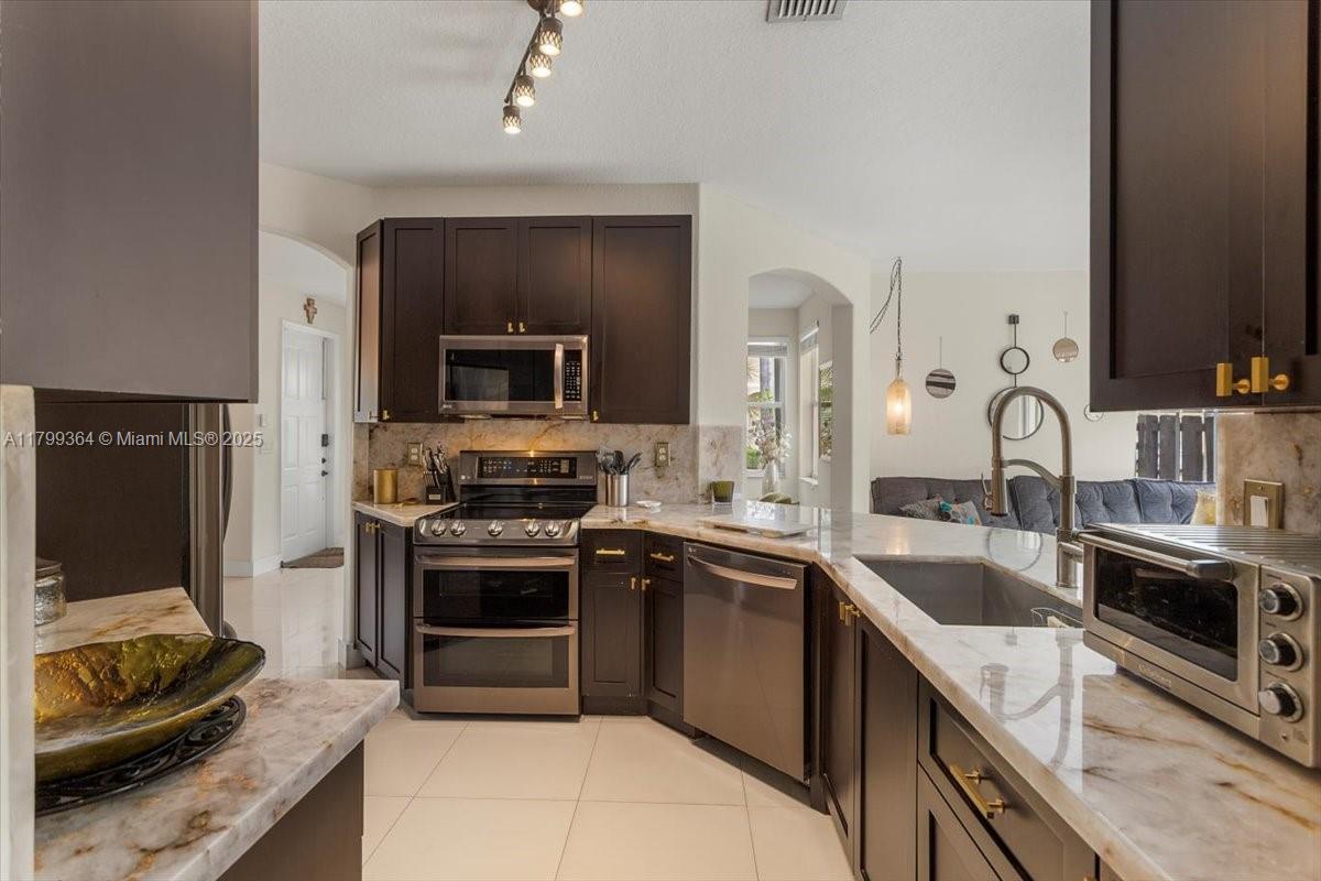 12367 Southwest 122nd Street Miami, FL 33186 - Photo 11 of 35 a kitchen with a sink stove and oven