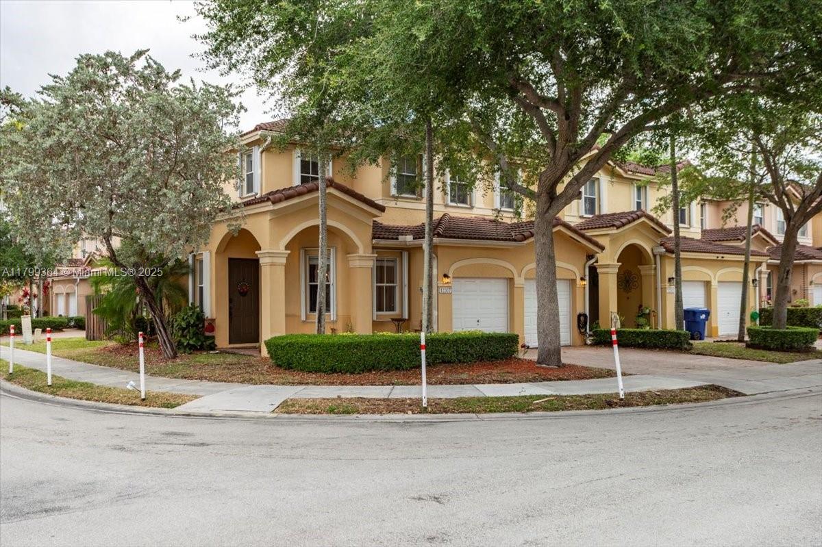 12367 Southwest 122nd Street Miami, FL 33186 - Photo 2 of 35 a view of a white house with large windows and a large tree