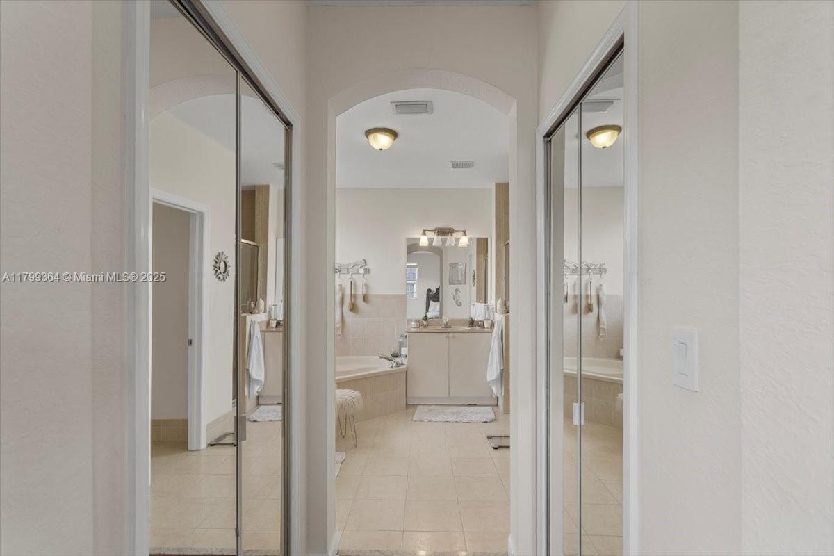 12367 Southwest 122nd Street Miami, FL 33186 - Photo 23 of 35 a bathroom with a glass shower door and a mirror