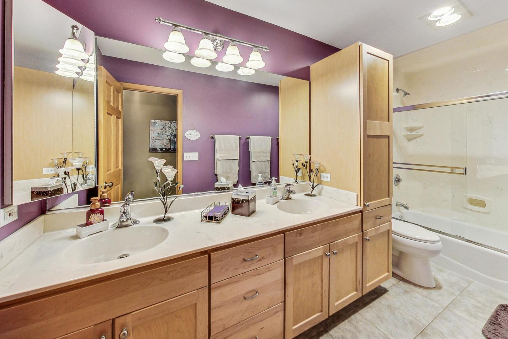 1020 South Linneman Road Mount Prospect, IL 60056 - Photo 54 of 70 a bathroom with double vanity sinks a toilet a large mirror and shower