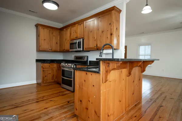 a kitchen with stainless steel appliances granite countertop a stove a sink and a microwave