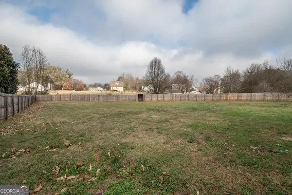 a view of a house with backyard and a tree