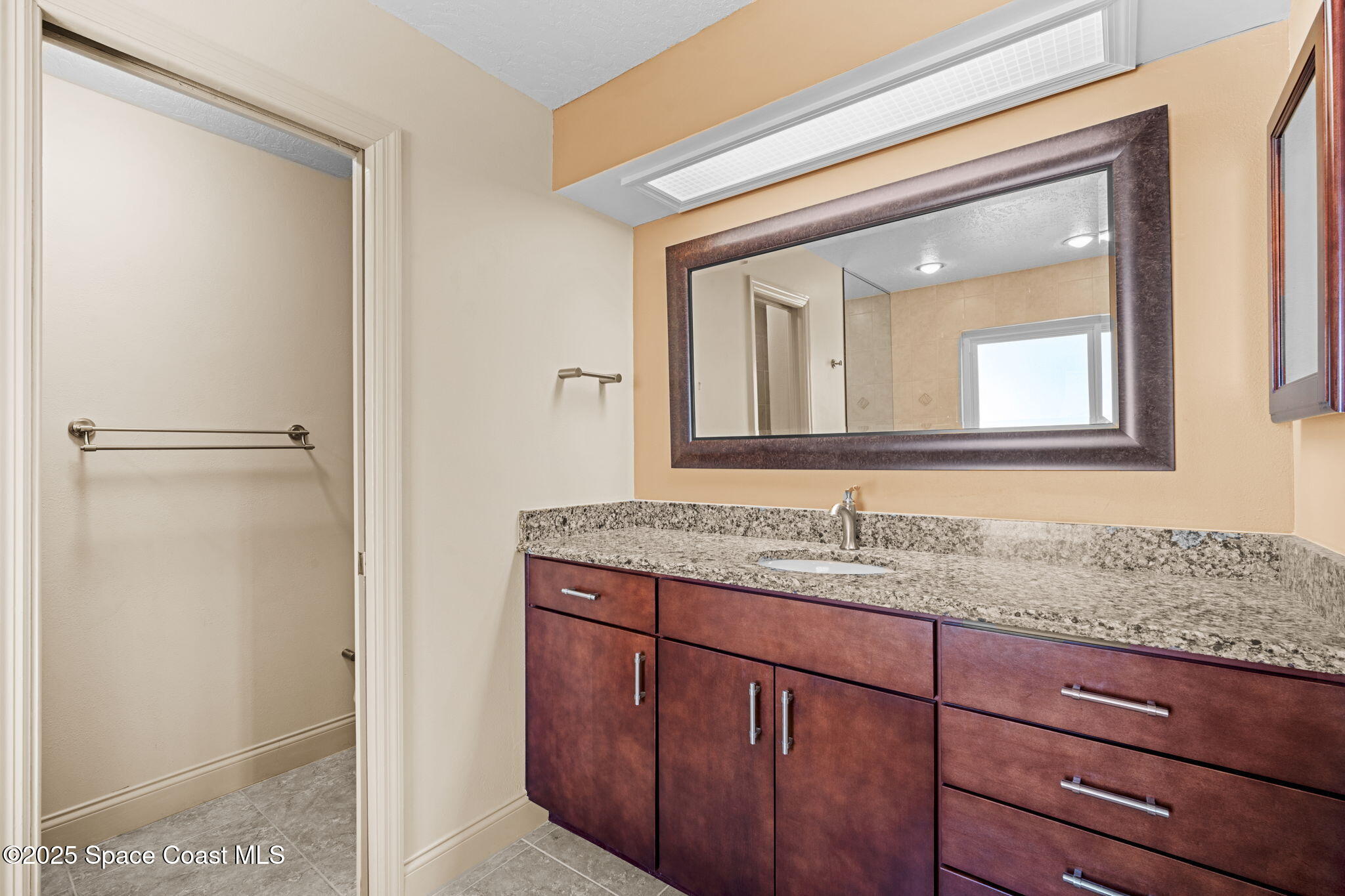 1940 Gates Road Merritt Island, FL 32952 - Photo 25 of 72 a bathroom with a granite countertop sink vanity and mirror