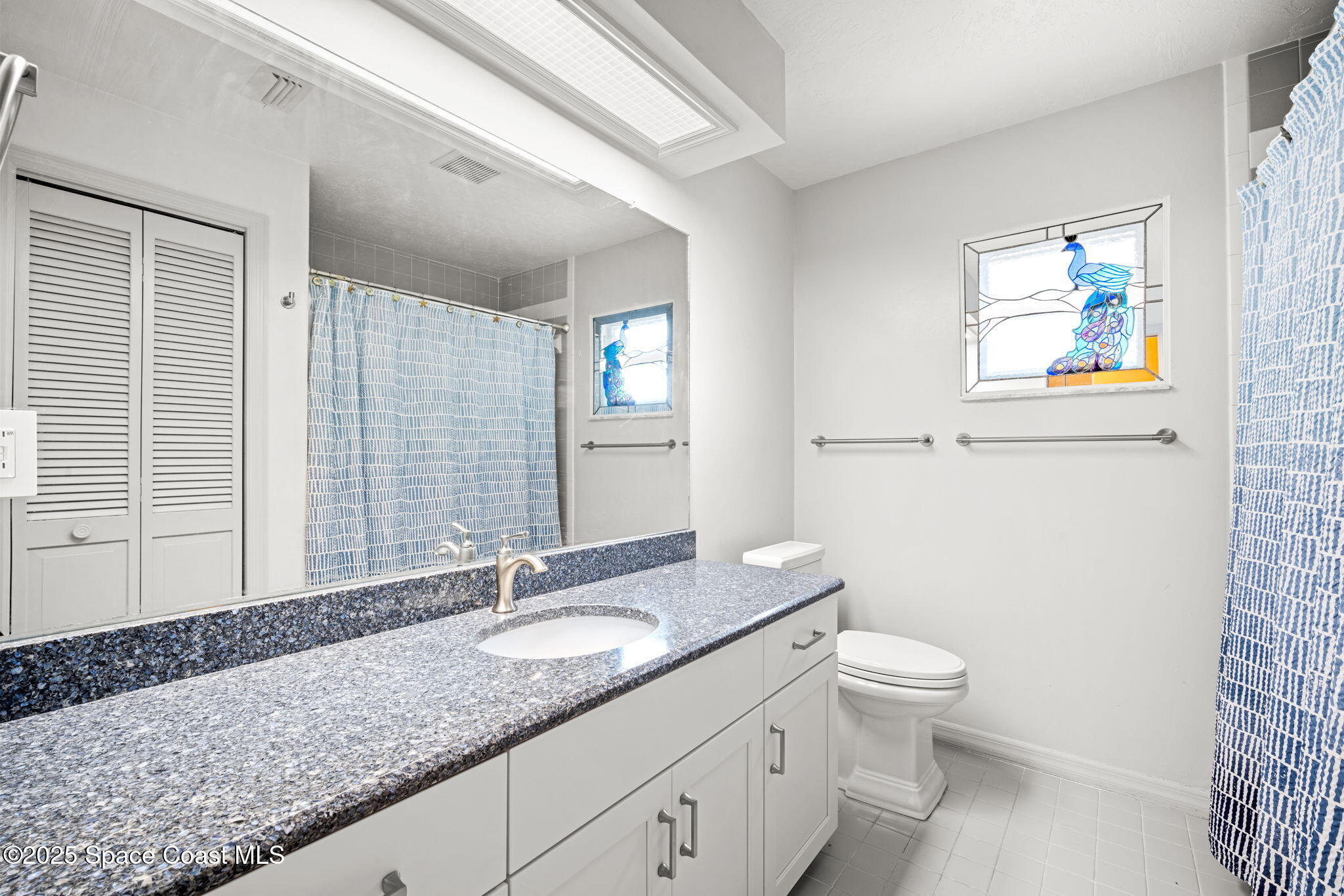 1940 Gates Road Merritt Island, FL 32952 - Photo 28 of 72 a bathroom with a granite countertop sink mirror vanity and toilet