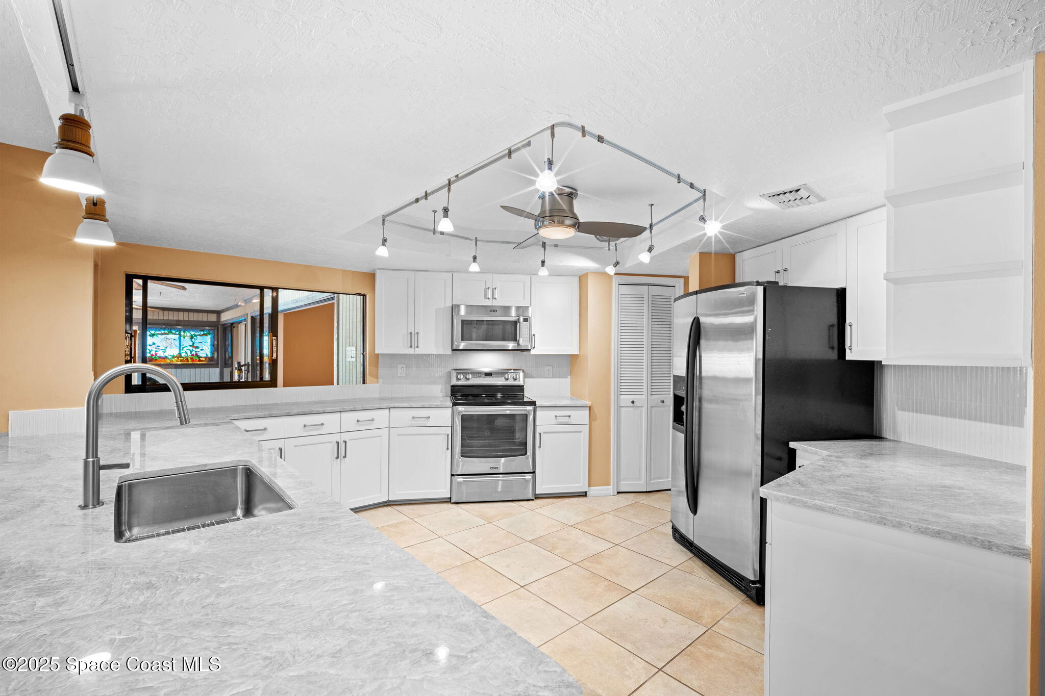 1940 Gates Road Merritt Island, FL 32952 - Photo 50 of 72 a kitchen with stainless steel appliances kitchen island granite countertop a refrigerator and a stove top oven
