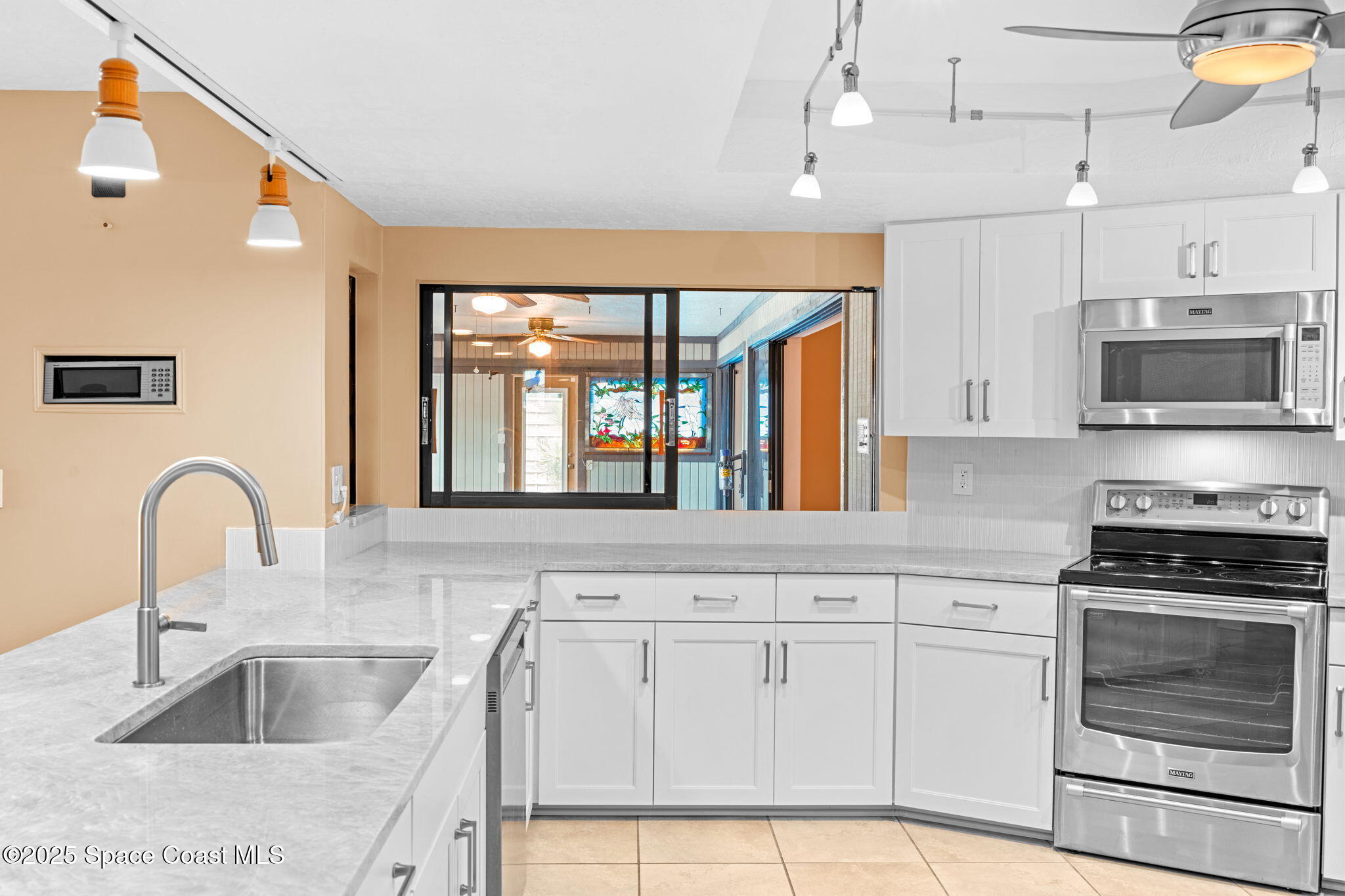 1940 Gates Road Merritt Island, FL 32952 - Photo 6 of 72 a kitchen with granite countertop a stove a sink and a microwave