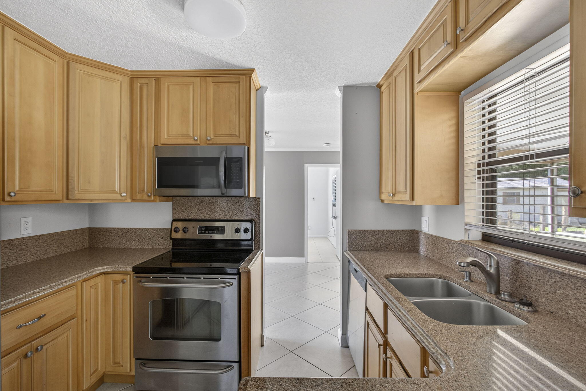 7107 181st Street Jupiter, FL 33458 - Photo 11 of 54 a kitchen with granite countertop a sink and a stove top oven