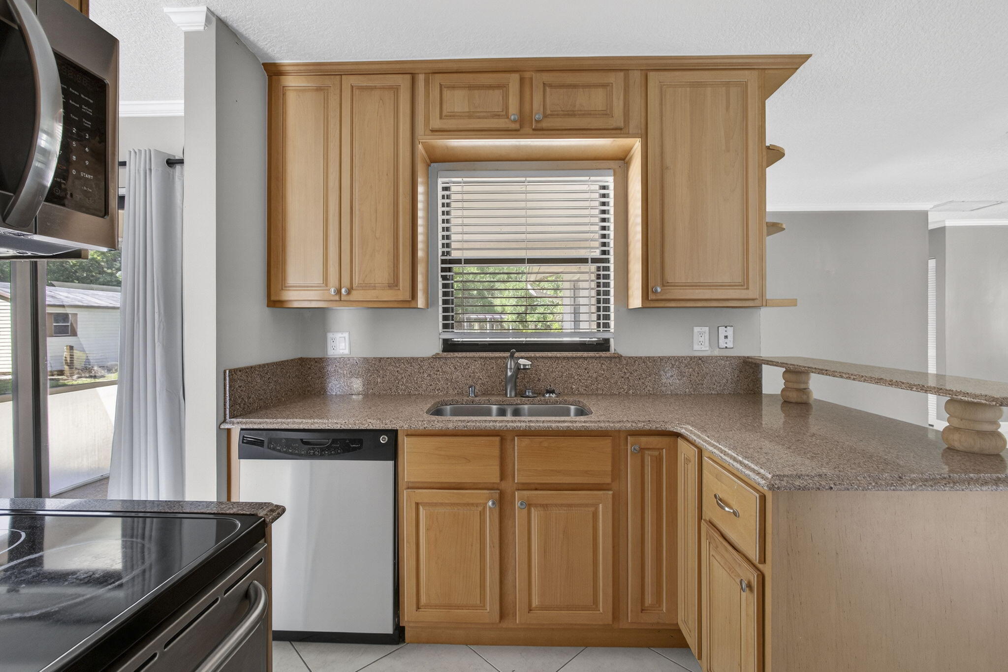 7107 181st Street Jupiter, FL 33458 - Photo 12 of 54 a kitchen with stainless steel appliances granite countertop a sink stove and cabinets