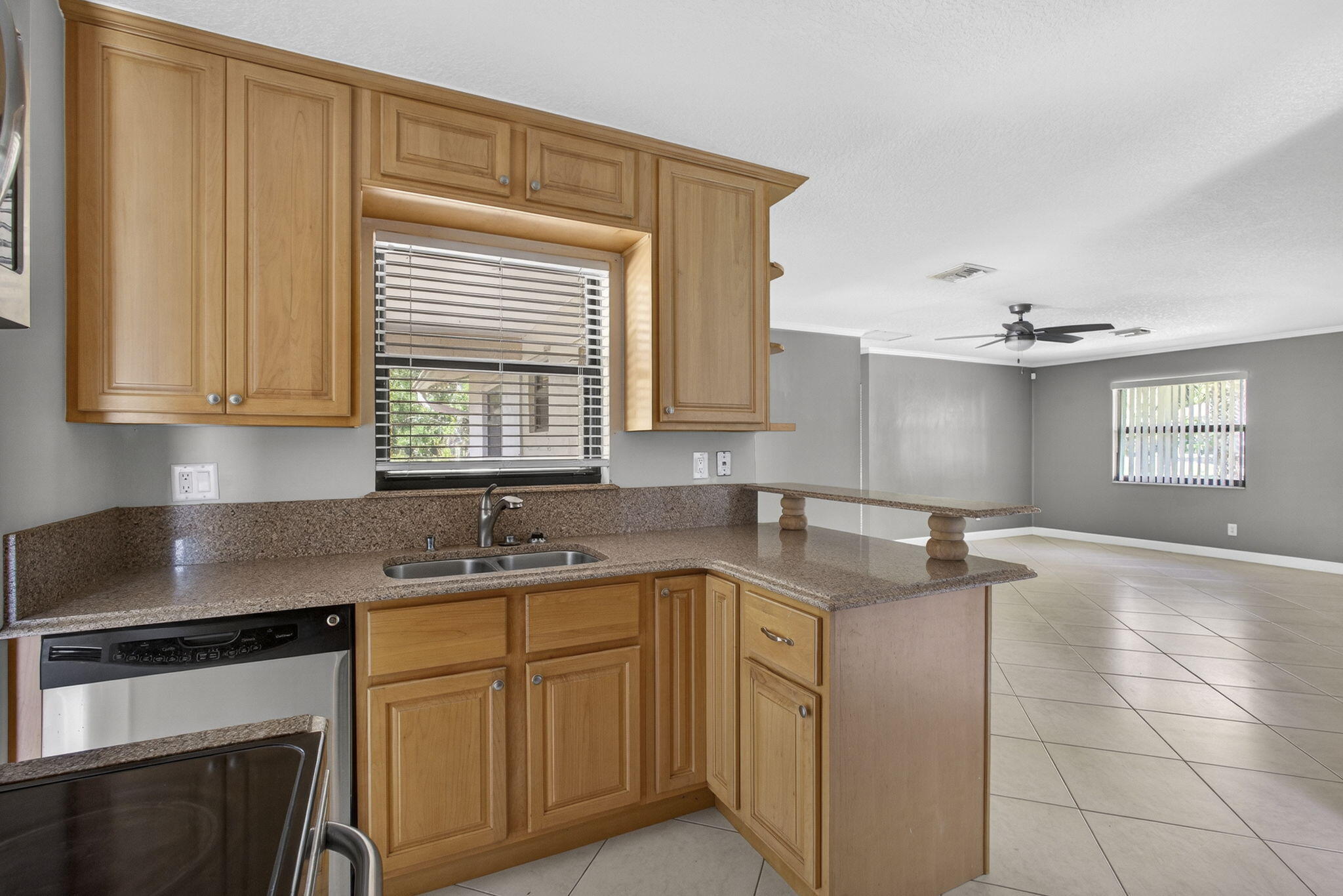7107 181st Street Jupiter, FL 33458 - Photo 13 of 54 a kitchen with granite countertop a sink stove and cabinets