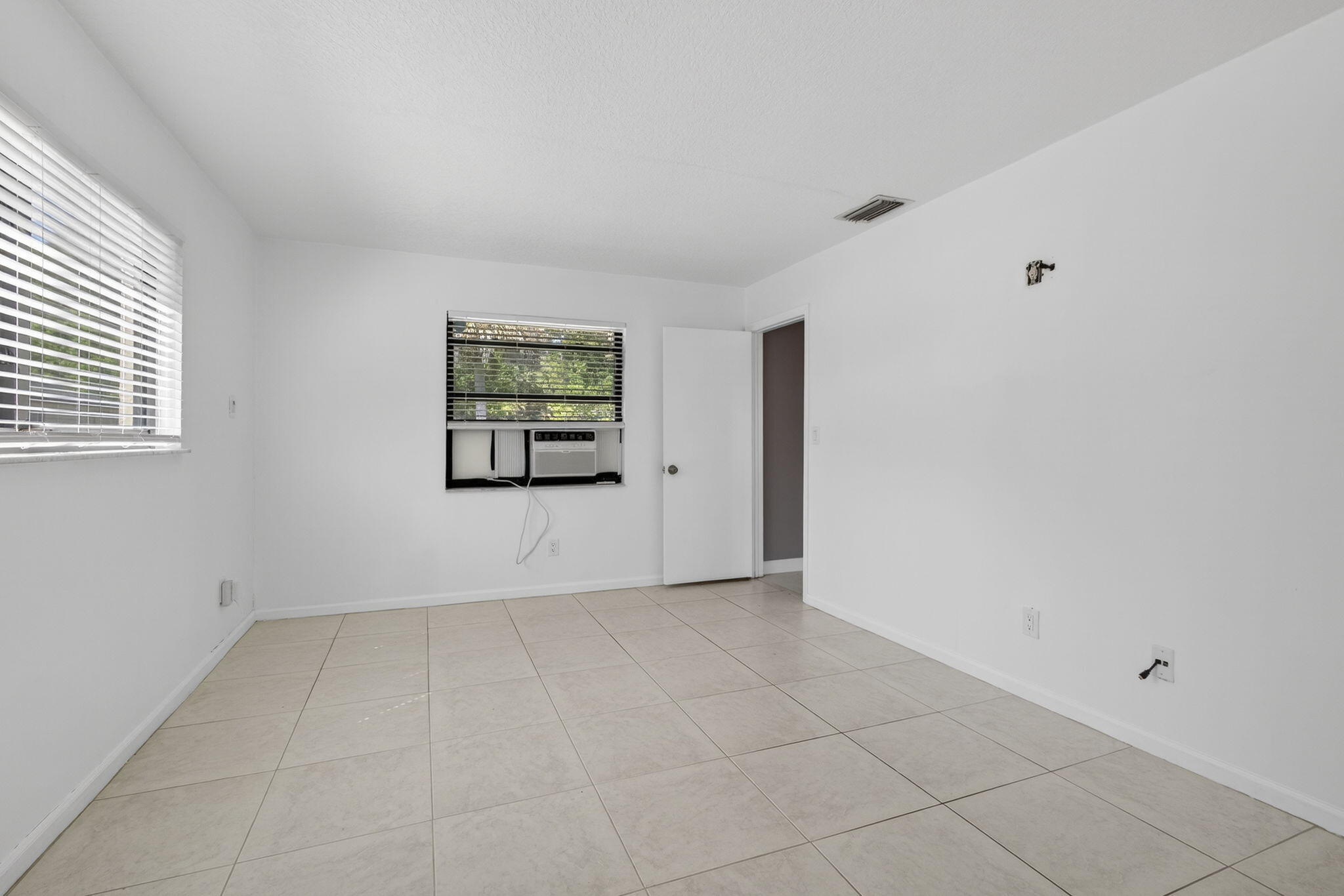 7107 181st Street Jupiter, FL 33458 - Photo 19 of 54 a view of an empty room with a window