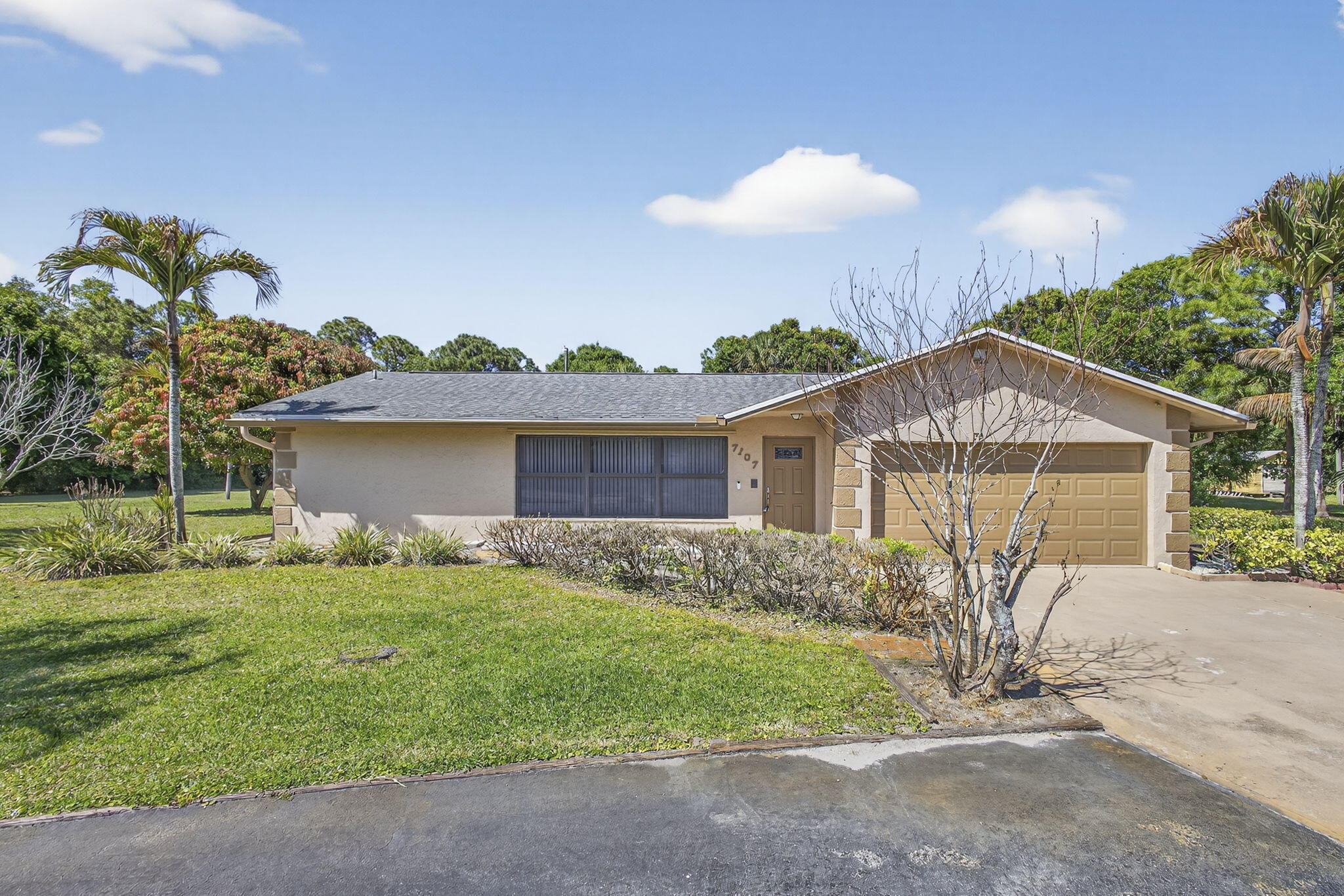 7107 181st Street Jupiter, FL 33458 - Photo 2 of 54 a front view of a house with garden