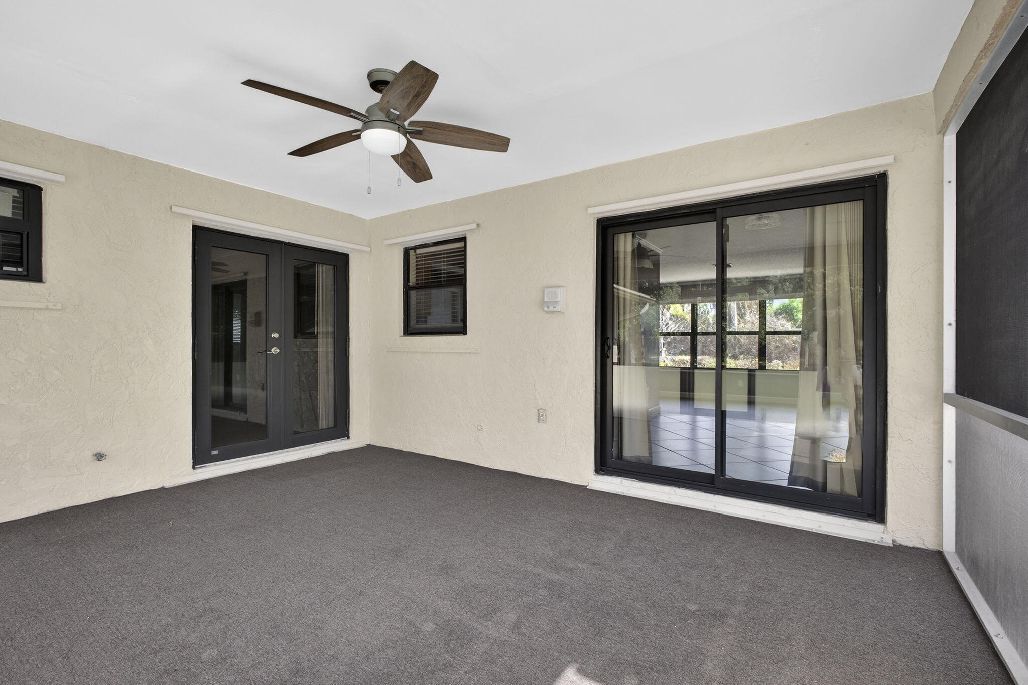 7107 181st Street Jupiter, FL 33458 - Photo 34 of 54 a view of an empty room with a ceiling fan and windows