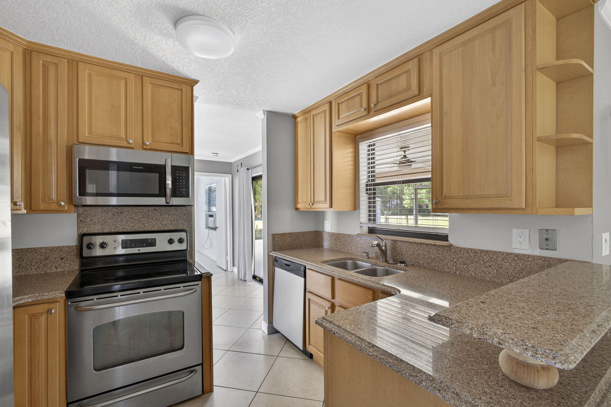 7107 181st Street Jupiter, FL 33458 - Photo 10 of 54 a kitchen with stainless steel appliances granite countertop a stove a sink and a microwave
