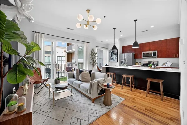 a living room with furniture kitchen view and a chandelier