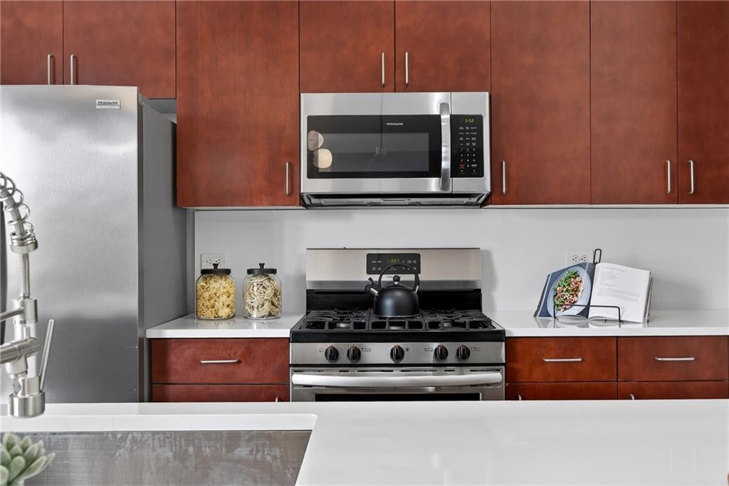 384 Ralph McGill Boulevard Northeast, Unit 322 Atlanta, GA 30312 - Photo 8 of 23 a kitchen with stainless steel appliances granite countertop a stove a microwave and a refrigerator