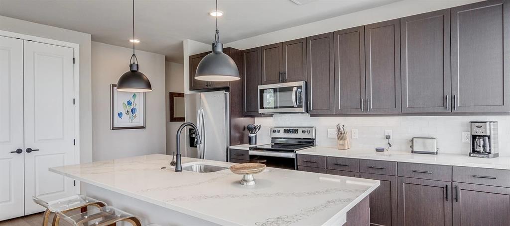 3900 Commerce Street, Unit 701 Dallas, TX 75226 - Photo 2 of 12 a kitchen with stainless steel appliances kitchen island granite countertop a sink a stove and cabinets