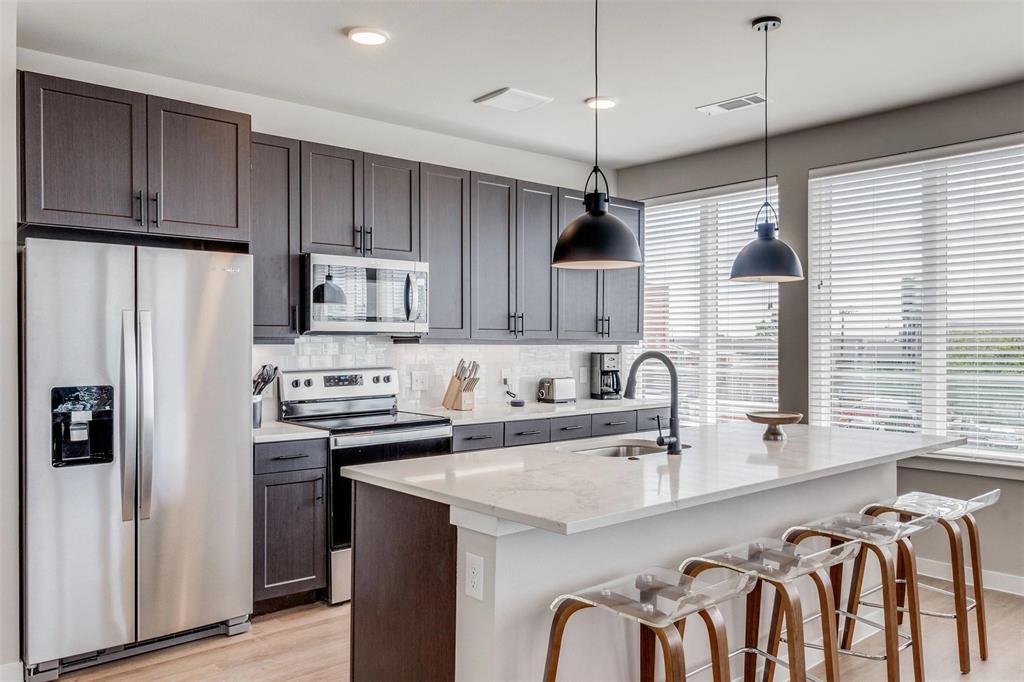 3900 Commerce Street, Unit 701 Dallas, TX 75226 - Photo 4 of 12 a kitchen with stainless steel appliances granite countertop a sink refrigerator and cabinets