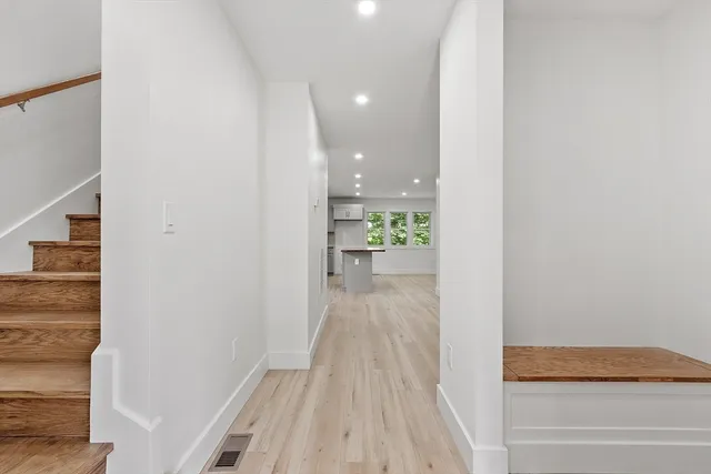 a view of a hallway with wooden floor and staircase