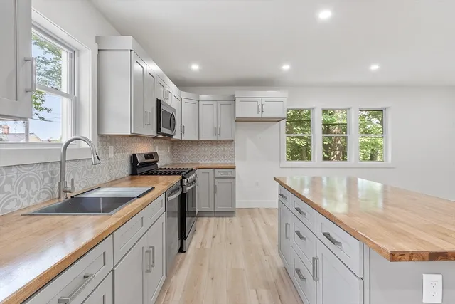 a kitchen with granite countertop a sink a counter space appliances and cabinets