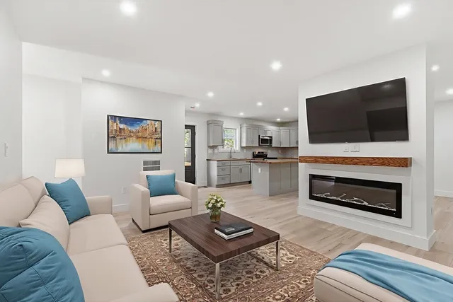 a living room with furniture a fireplace and a flat screen tv