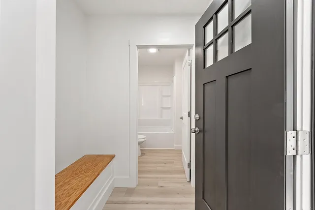 a view of a hallway with wooden floor and staircase