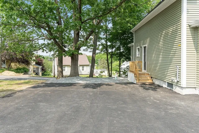 a view of a house with a patio and a yard