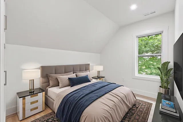 a bedroom with a bed a bookshelf and a window