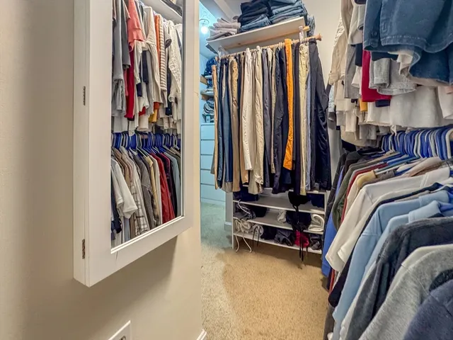 a view of walk in closet with clothes and shoes